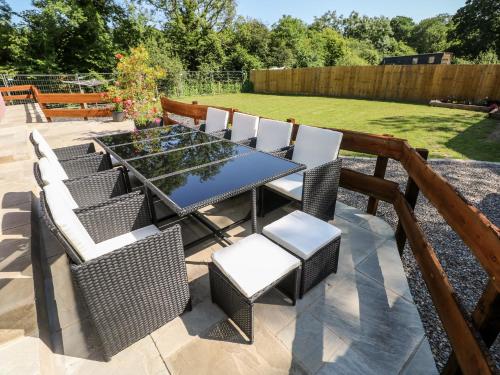 a patio with a table and chairs and a garden at 1 The Warren in Narberth