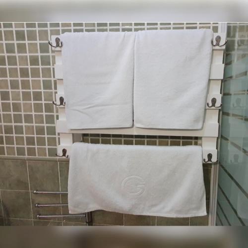a group of towels hanging on a rack in a bathroom at GirasolesV in Sanlúcar de Barrameda