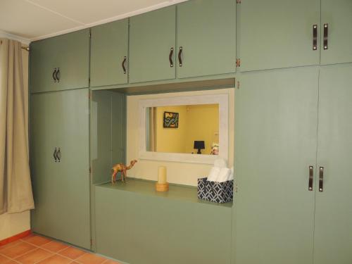 a room with green cabinets and a mirror at Stone Haven at Nieu Bethesda in Nieu-Bethesda