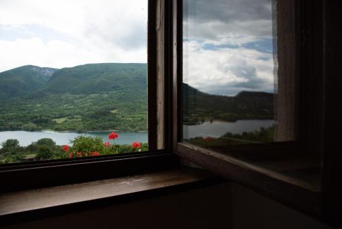 a window with a view of a lake and mountains at La Poiana in Barrea