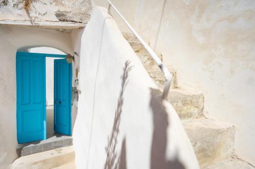 eine blaue Tür in einer Treppe mit einem Schatten in der Unterkunft La Dependance - Gioia Apartments in Procida