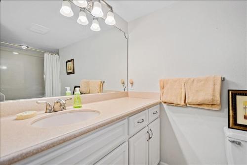 een badkamer met een wastafel en een grote spiegel bij Sea Oats 241 Apartment in Boca Grande