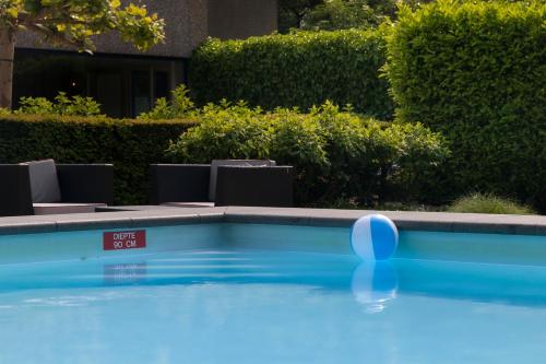a swimming pool with a ball in the water at Novotel Rotterdam - Schiedam in Schiedam