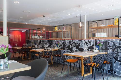 a restaurant with tables and chairs in a room at Novotel Rotterdam - Schiedam in Schiedam