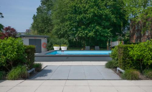 a swimming pool in a yard with plants at Novotel Rotterdam - Schiedam in Schiedam