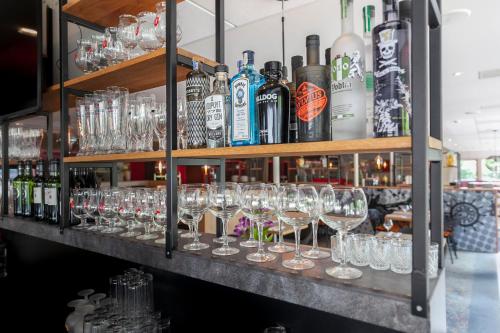 a bunch of glasses on a shelf in a bar at Novotel Rotterdam - Schiedam in Schiedam