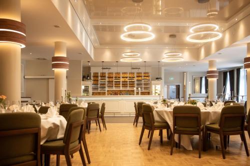 a dining room with white tables and chairs at Hotel Haberkamp in Achim