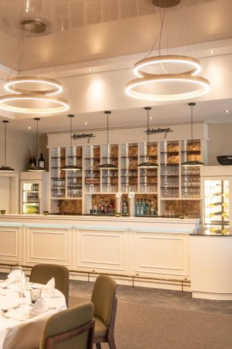 a dining room with white cabinets and tables and lights at Hotel Haberkamp in Achim