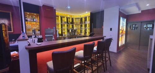 a bar in a restaurant with a bunch of stools at Hotel Wettiner Hof in Riesa