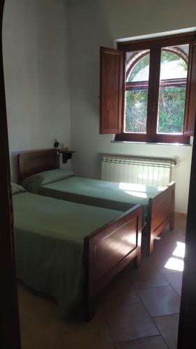 a bedroom with two beds and a window at Fattoria Armonia in Stilo