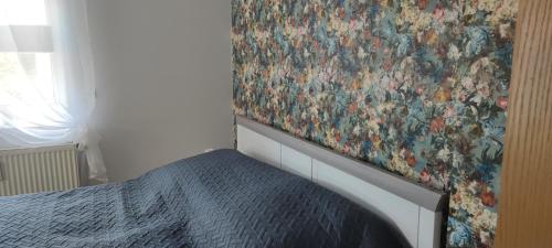 施瓦岑堡的住宿－Ferienwohnung Dick Schwarzenberg，卧室,墙上挂着一幅画,床边是