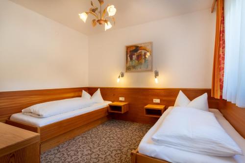a room with two beds and a table at Kinderhotel Lärchenhof in Obsteig
