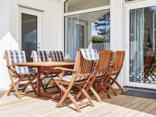 a wooden table and chairs on a porch at 6 person holiday home in Slagelse in Slagelse