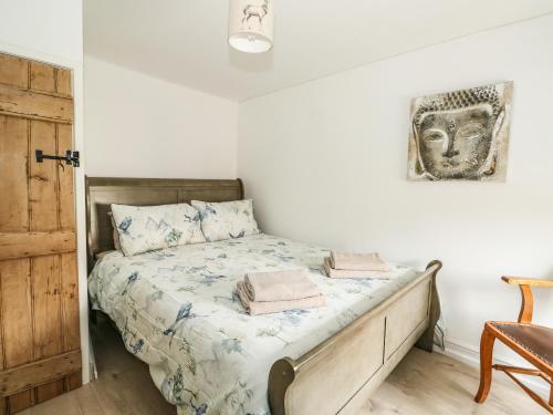 a bedroom with a bed with a wooden headboard at Apple Tree Cottage in Lincoln