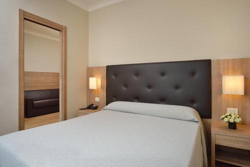a bedroom with a large bed and a mirror at Hotel Rossini in Pesaro