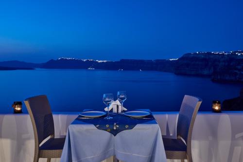 a table with two wine glasses on top at Santorini View in Akrotiri