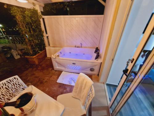 a bathroom with a tub and a table and a chair at luxury B&B e FAMILY RESIDENCE VILLA FILOMENA in Marina di Camerota