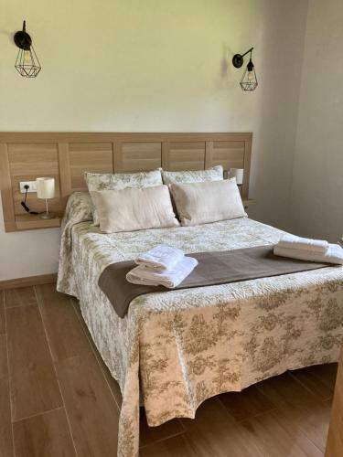 sypialnia z dużym łóżkiem z dwoma ręcznikami w obiekcie Apartamentos La Presa El Molin w mieście Cangas de Onís
