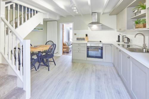 uma cozinha com uma mesa e uma sala de jantar em Host & Stay - Spring Cottage em Whitby
