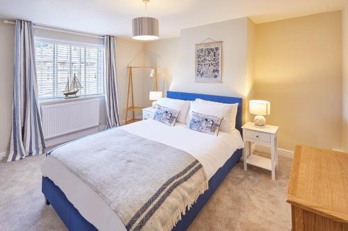 um quarto com uma cama azul e branca e uma janela em Host & Stay - Spring Cottage em Whitby