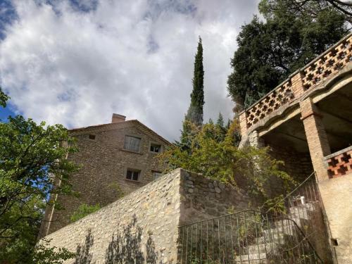 a building with a fence and a tree in the background at Domaine La Tour - SPA - Jacuzzi - Sauna - Massage - 4 SAISONS - Piscine Chauffée Toute l'année - Heated POOL - 800m City Centre Nyons in Nyons
