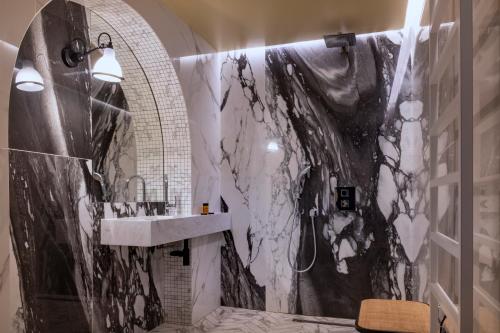 a bathroom with a black and white marble wall at Hôtel De La Paix in Paris