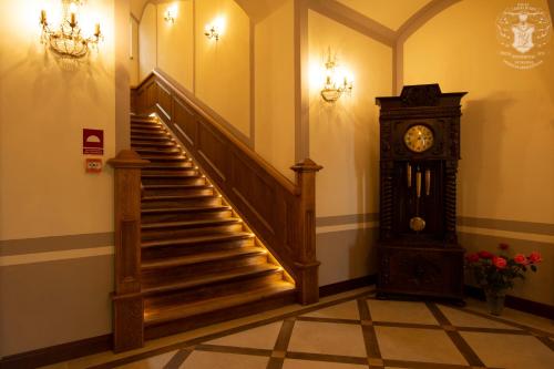 a staircase with a grandfather clock in a building at Pałac Lubiechowa-Jelenia Góra- Riesengebirge in Lubiechowa