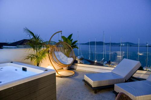 a jacuzzi tub on a balcony with a view of the ocean at The Well View in Preveza
