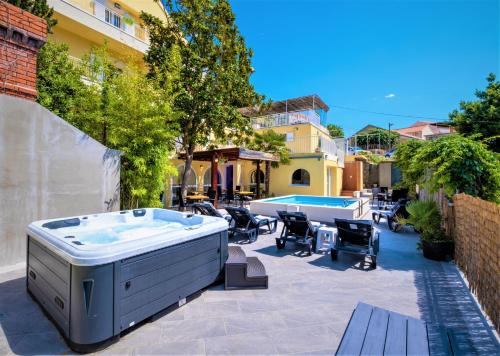 uma banheira de hidromassagem situada num pátio ao lado de um edifício em Castelletto em Cavtat