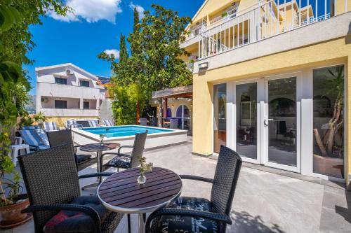 een patio met tafels en stoelen en een zwembad bij Castelletto in Cavtat