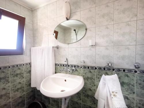 a bathroom with a white sink and a mirror at Villa Mirage in Sozopol