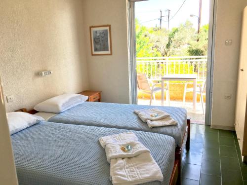 two beds in a room with a balcony at Galini Studios and Apartments in Lassi