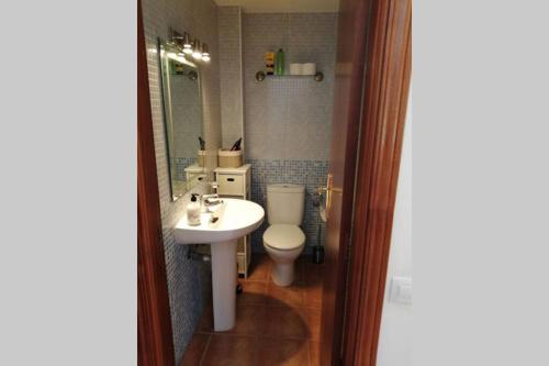a bathroom with a sink and a toilet and a mirror at Fuertedreams in La Oliva