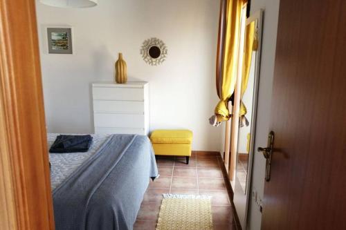 a bedroom with a bed and a yellow chair at Fuertedreams in La Oliva