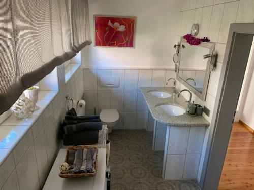 a bathroom with two sinks and a mirror at Haus Zwölf in Dahn