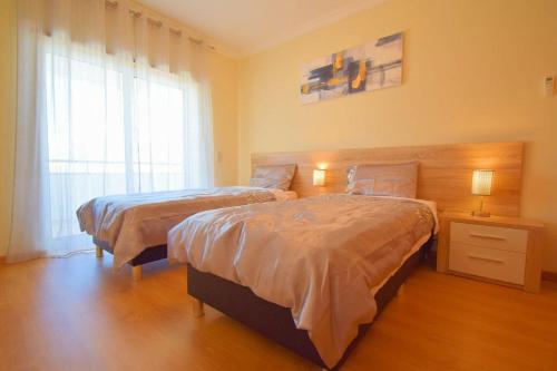 アルブフェイラにあるPerfect New Apartment in Albufeiraのベッドルーム1室(ベッド2台、窓付)