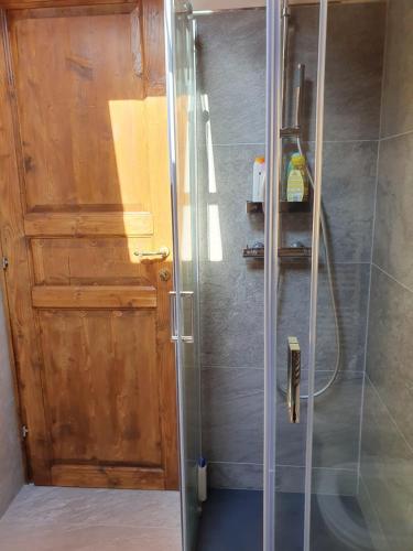 a shower with a wooden door in a bathroom at Mansarda bilocale centro Brusson in Brusson