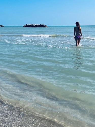 a woman standing in the water at the beach at Hotel La Terrazza in Porto San Giorgio