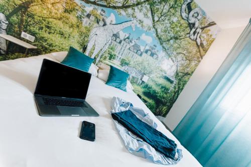 a laptop computer sitting on top of a bed at ibis Styles Contres-Cheverny in Le Controis En Sologne
