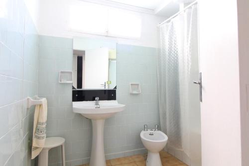 uma casa de banho com um lavatório, um WC e um espelho. em Global Properties, Casa rural en Quartell con encanto em Cuartell
