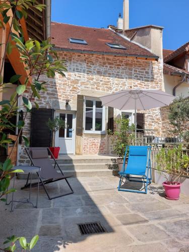 a patio with two chairs and an umbrella at L'INATTENDU Vue imprenable,clim,parking avec borne de recharge, ménage inclus in Montaigu