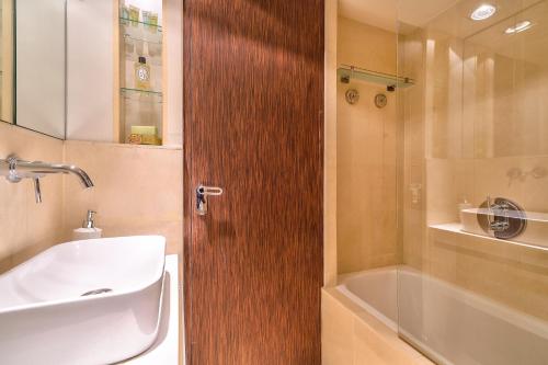 een badkamer met een wastafel en een houten deur bij Designed Studio with AC-Terrasse Vue Tour Eiffel in Parijs