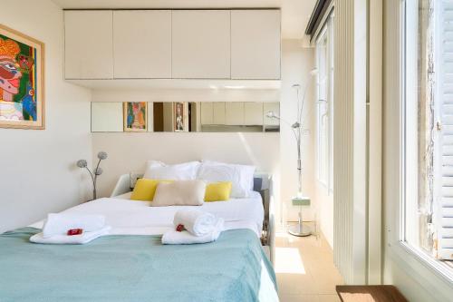 een slaapkamer met een groot bed en handdoeken bij Designed Studio with AC-Terrasse Vue Tour Eiffel in Parijs