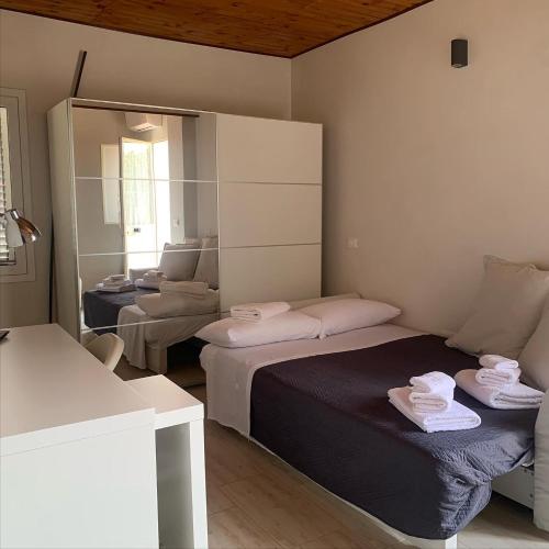 a small room with two beds and a mirror at La Caletta di Afrodite in Calabernardo