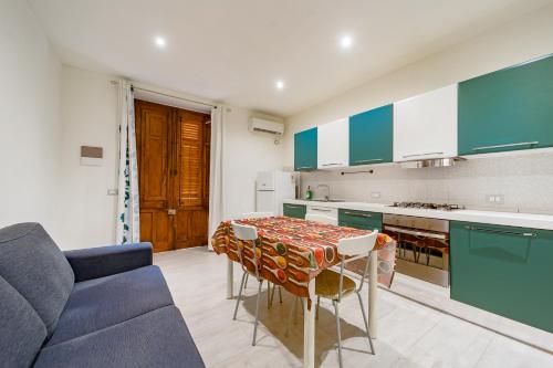 une cuisine avec une table et un canapé bleu dans l'établissement Naranji House Blue - Relax, à Altavilla Milicia