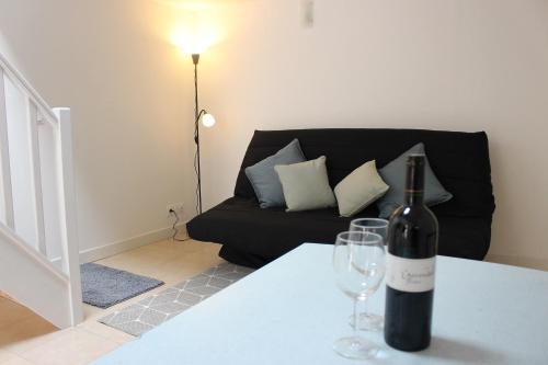 a bottle of wine sitting on a table with a wine glass at Gîte proche canal La Conserverie in Buzet-sur-Baïse