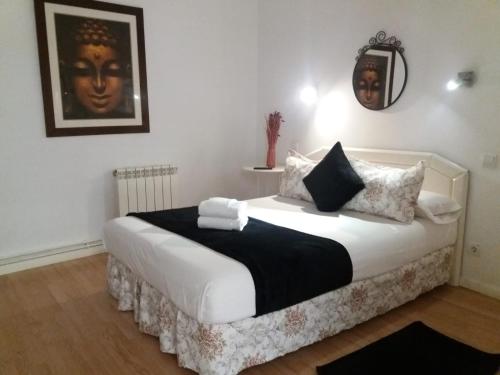1 dormitorio con cama blanca y almohadas blancas y negras en Casa de Huéspedes Prada, en Madrid