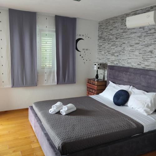 a bedroom with a large bed with towels on it at Apartmani Mira Brela in Brela