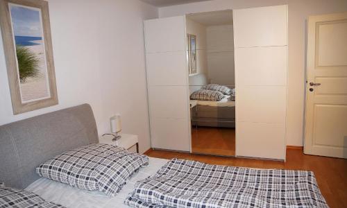 a bedroom with a bed and a mirror at HansaResidenz Scharbeutz in Scharbeutz