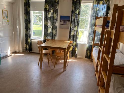 einen Tisch und Stühle in einem Zimmer mit Fenstern in der Unterkunft Gefle vandrarhem in Gävle